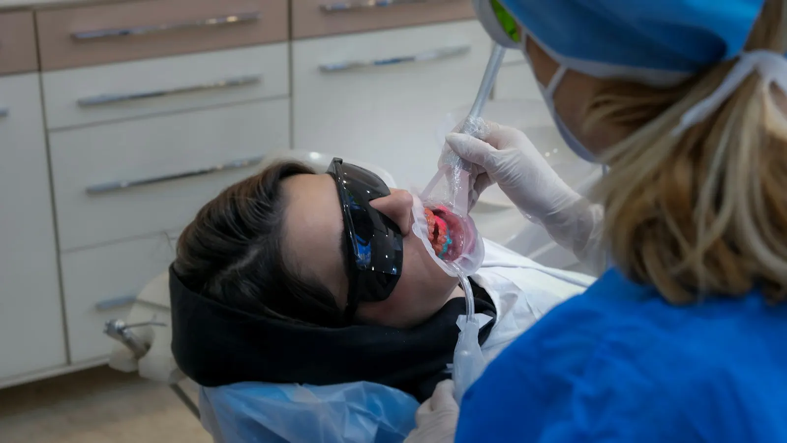 A patient in protective glasses in the treatment chair